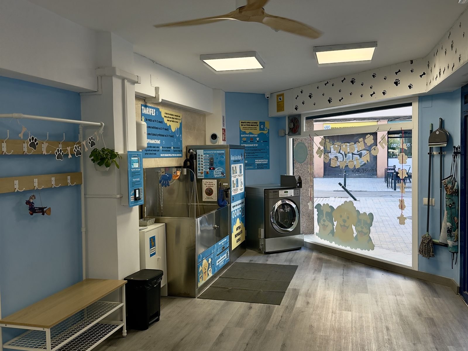 Interior del local con la bañera, la lavadora y la entrada
